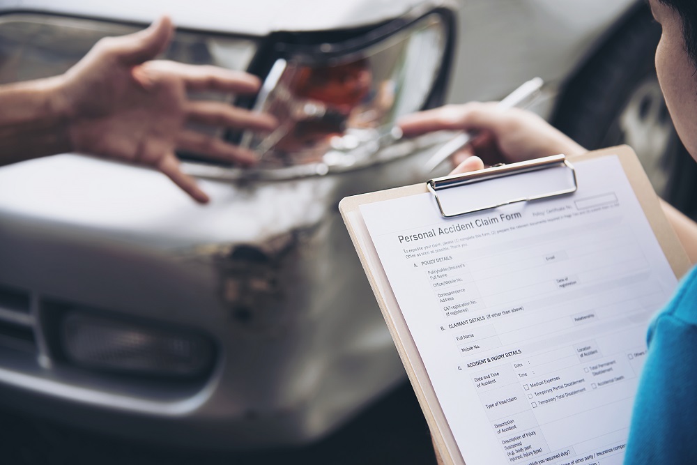 Insurance agent working during on site car accident claim process - people and car insurance claim concept